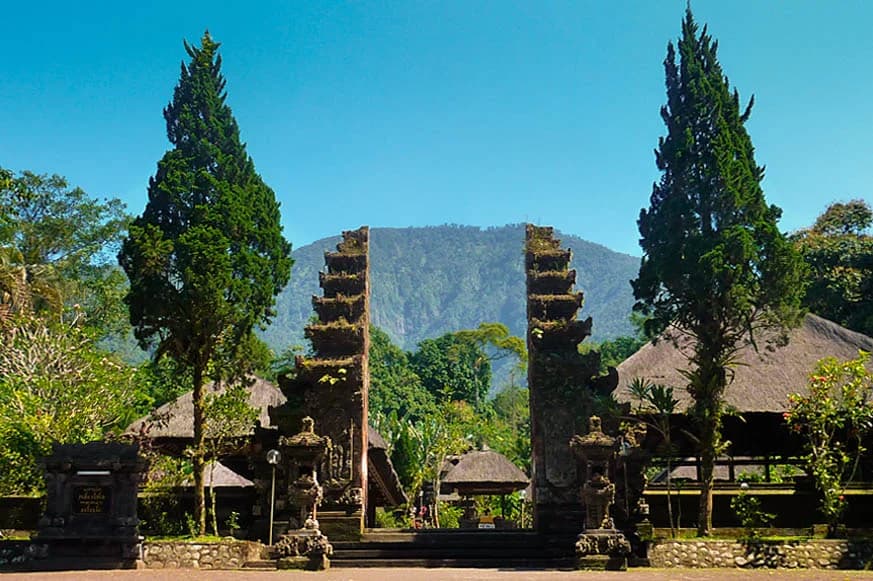 Batukaru Temple Bali features majestic stone gateways surrounded by lush greenery and mountains near Besakih Mother Temple.
