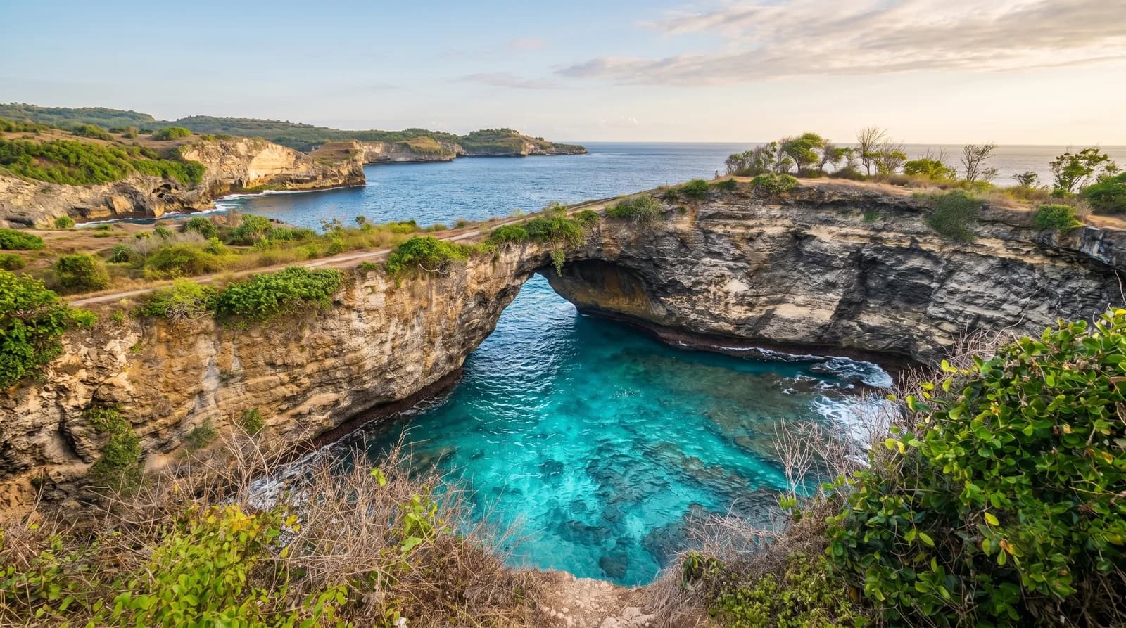 Scenic overview of Broken Beach Nusa Dua, featuring turquoise waters, rocky cliffs, and lush greenery.