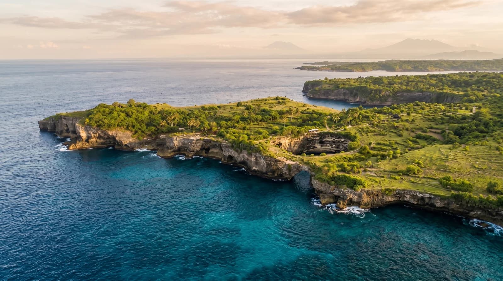 Scenic overview of Broken Beach Nusa Dua, showcasing rugged coastline, lush greenery, and tranquil blue waters.