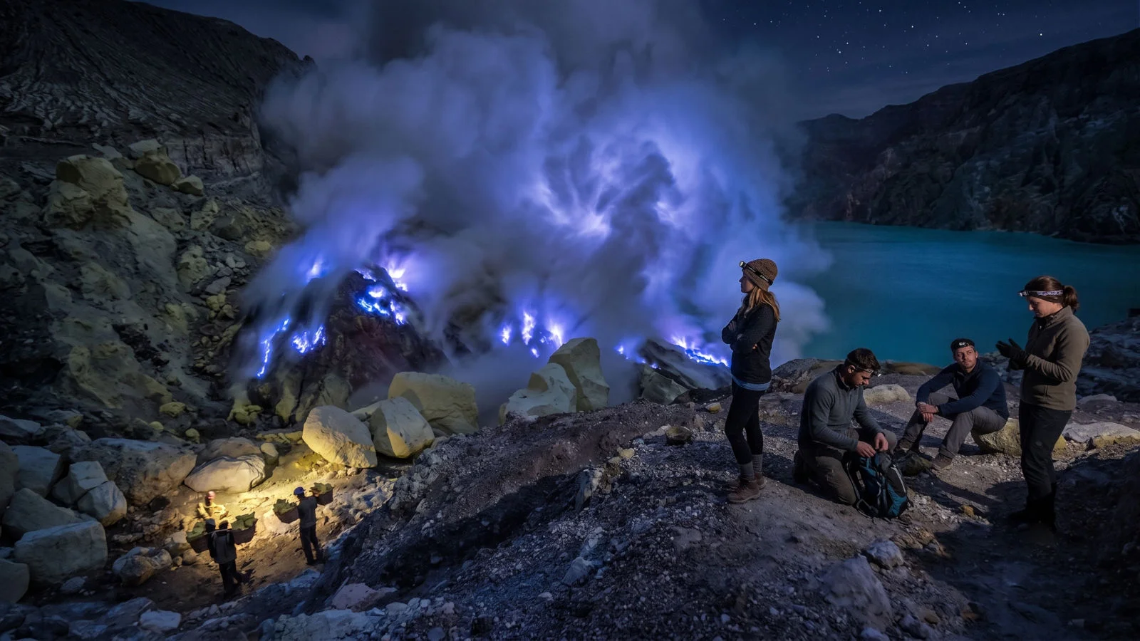 Mystical electric blue fire glowing in the sulfur vents of Mount Ijen crater at night