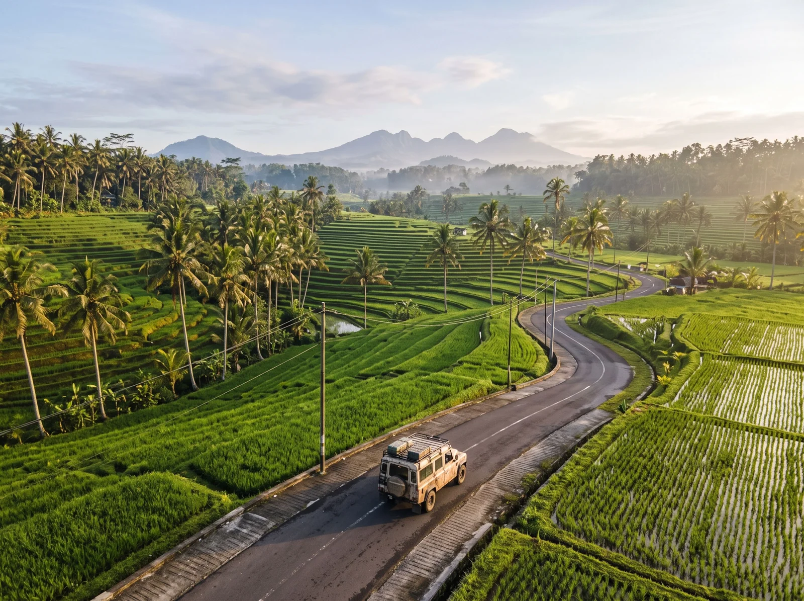 A car driving along a road through rice fields on the way to Ubud