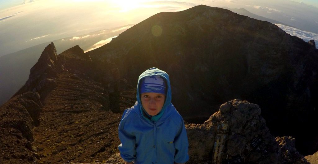 Семилетняя девочка встречает рассвет на вулкане Агунг